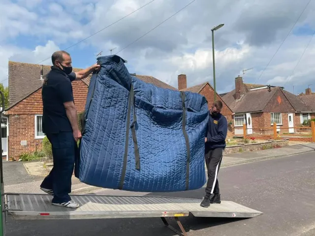Reliable Removals crew carrying furniture during a house move